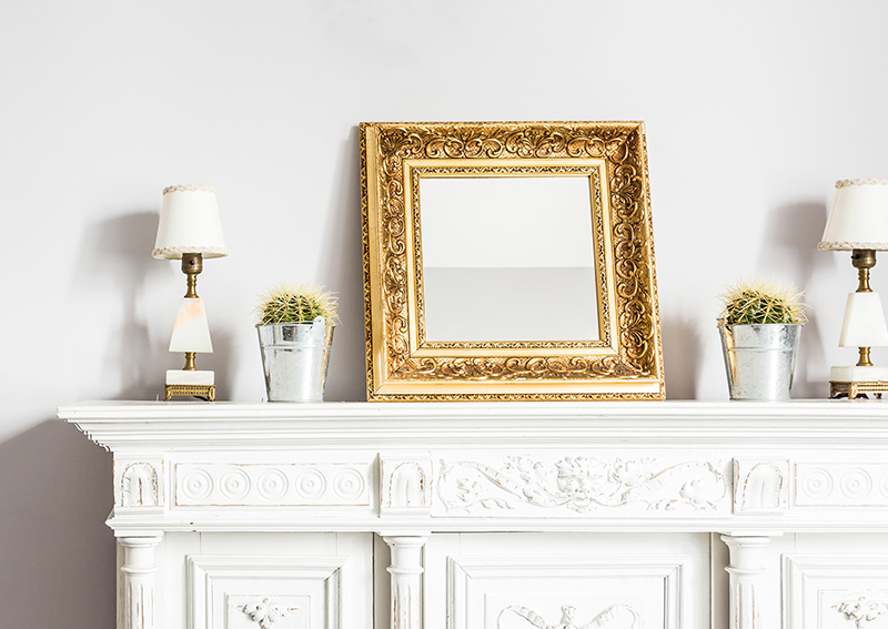 De koninklijke pracht van een gouden baroklijst siert de open haard in de woonkamer.